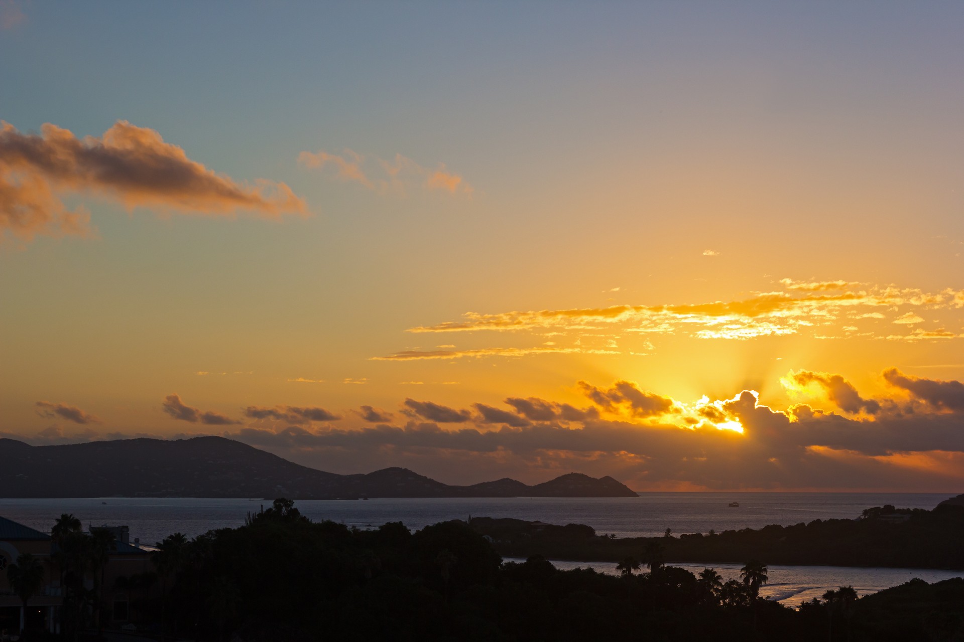 Sun about to appear above the clouds at sunset on St Thomas Island, US VI.